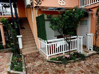 a house with a white porch and a white fence at Apartmani GS ***** Zavidovici in Zavidovići