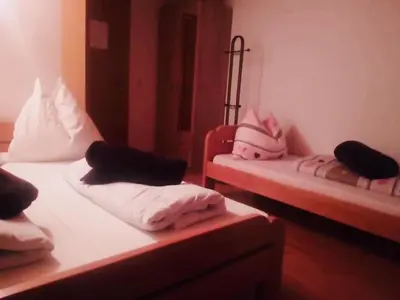 two beds in a room with pink pillows on them at OMLADINSKI HOTEL ROSTOVO in Bugojno