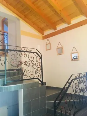 a staircase in a house with a metal railing at OMLADINSKI HOTEL ROSTOVO in Bugojno