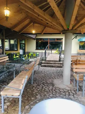 a group of benches in a building with tables and chairs at OMLADINSKI HOTEL ROSTOVO in Bugojno