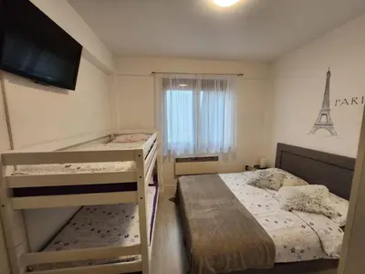 a small bedroom with two bunk beds and a television at Apartman Panorama in Kupres