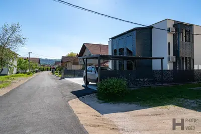 a house with a car parked next to a street at Hazam Aparthotel in Sanski most