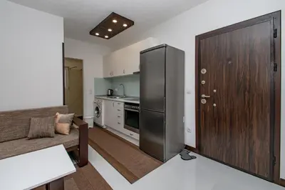 a kitchen with a stainless steel refrigerator in a living room at Hazam Aparthotel in Sanski most
