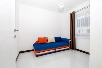 a blue couch in a room with a window at Hazam Aparthotel in Sanski most