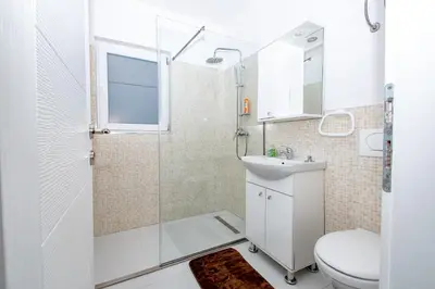 a bathroom with a shower and a toilet and a sink at Hazam Aparthotel in Sanski most
