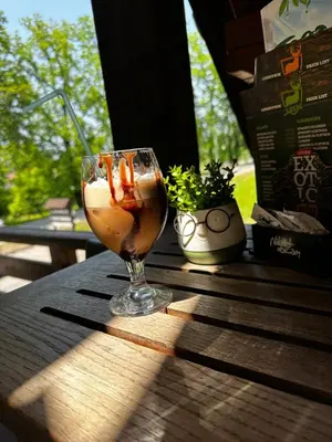 a drink in a glass sitting on a wooden table at Prenoćište/Restoran Lovac in Bihać