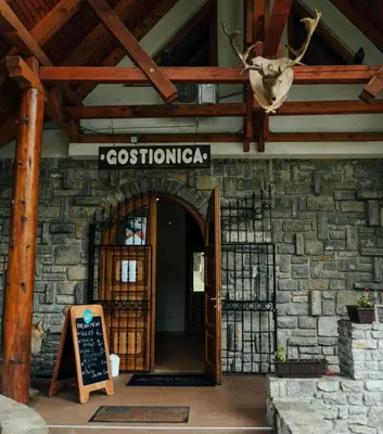 a door to a building with a sign on it at Prenoćište/Restoran Lovac in Bihać