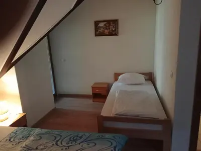 a small bedroom with two beds and a staircase at Prenoćište/Restoran Lovac in Bihać