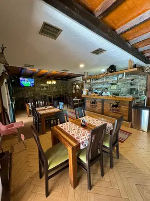 a restaurant with tables and chairs and a bar at Prenoćište/Restoran Lovac in Bihać