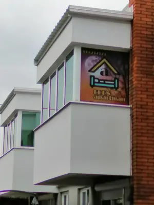 a building with a sign on the side of it at Apartman EDEN No 1 in Teslić