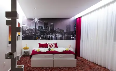 a bedroom with a large bed with red curtains at Hotel Biss in Zenica