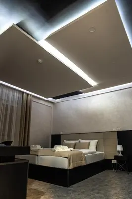 a bedroom with a large bed with a ceiling at Hotel Biss in Zenica
