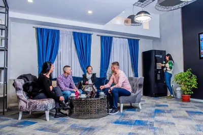a group of people sitting in a living room at Hotel Biss in Zenica