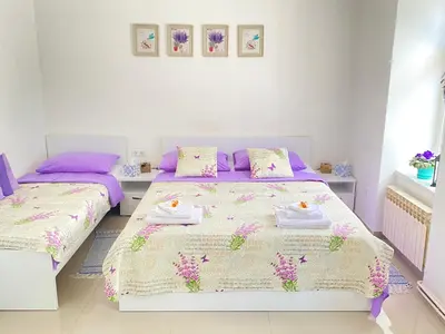 two beds in a bedroom with purple and white at Korzo Tuzla in Tuzla