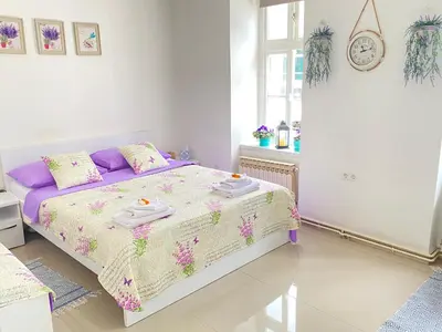 a white bedroom with a bed with towels on it at Korzo Tuzla in Tuzla