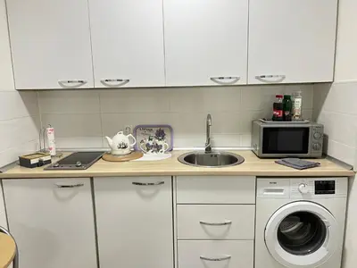 a kitchen counter with a sink and a microwave at Korzo Tuzla in Tuzla