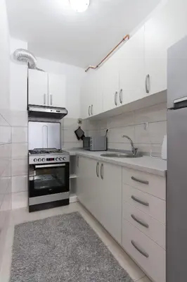 a white kitchen with a stove and a sink at Apartman Carica in Visoko