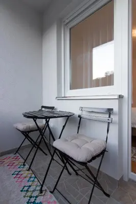 two chairs and a table in a room with a window at Apartman Carica in Visoko