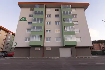 a tall apartment building with green and white at Apartman Carica in Visoko