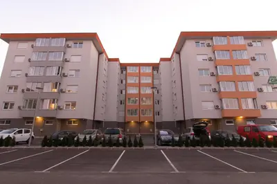 a parking lot with parked cars in front of buildings at Apartman Carica in Visoko