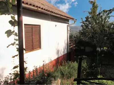 a white house with a window on the side of it at Cozy House in Jazvine with Garden in Jazvine