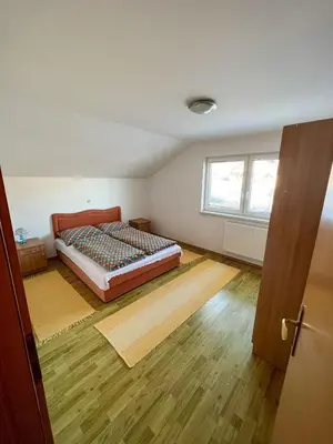 a bedroom with a bed and a wooden floor at Kuća Vesna in Kupres