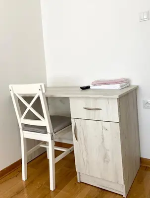a white desk with a chair next to a wall at Banja Luka 03 in Banja Luka