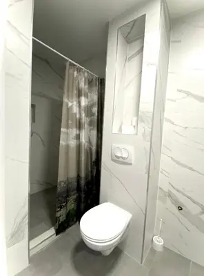 a white bathroom with a toilet and a shower at Banja Luka 03 in Banja Luka