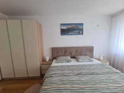 a bedroom with a bed with a striped comforter at Banja Luka 03 in Banja Luka