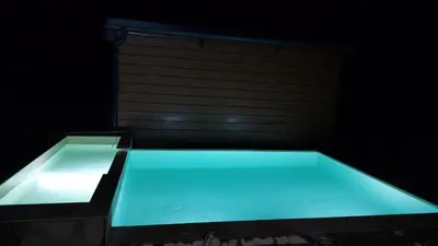 a swimming pool with blue light in a dark room at Bungalovi Ključ in Ključ