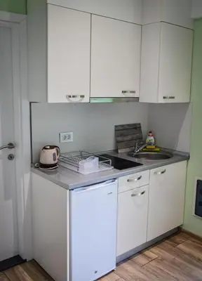 a kitchen with white cabinets and a counter top at Bungalovi Ključ in Ključ