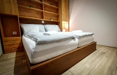 a bedroom with a large bed with a wooden headboard at Bungalovi Ključ in Ključ