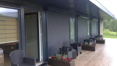 a building with chairs and flowers on the side of it at Bungalovi Ključ in Ključ