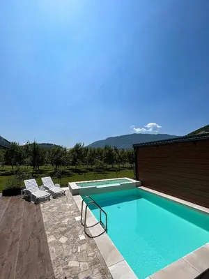 a swimming pool with two lounge chairs next to it at Bungalovi Ključ in Ključ