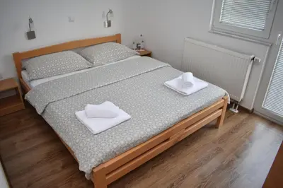 a bedroom with a bed with two white towels on it at Apartmani Vila in Kupres