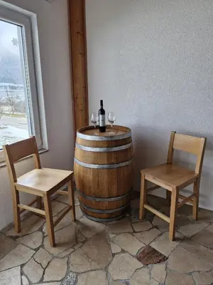 a wine barrel with two chairs and a bottle of wine at Apartmani Vila in Kupres