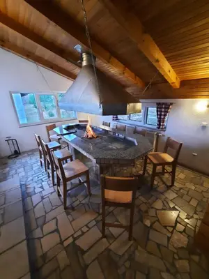 a kitchen with a table and chairs and a fireplace at Apartmani Vila in Kupres