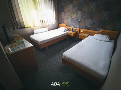 a hotel room with two beds and a television at Garni Motel Aba in Travnik
