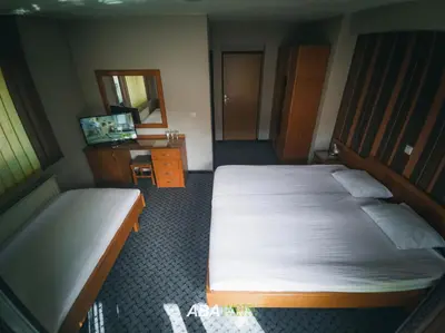 a hotel room with two beds and a mirror at Garni Motel Aba in Travnik