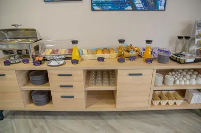 a wooden counter with plates and food on it at Hotel Soni Lux in Tuzla
