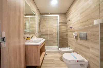 a bathroom with a toilet and a sink and a shower at Hotel Soni Lux in Tuzla