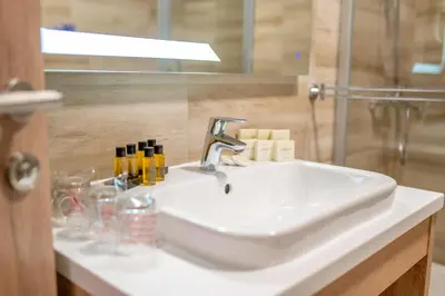 a white sink in a bathroom with a shower at Hotel Soni Lux in Tuzla