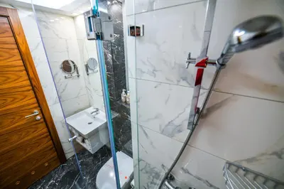a bathroom with a shower and a toilet and a sink at Hotel Zepter Palace in Banja Luka