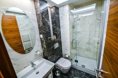 a bathroom with a sink and a toilet and a mirror at Hotel Zepter Palace in Banja Luka