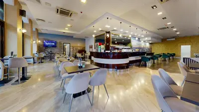 a restaurant with tables and chairs and a bar at Hotel Zepter Palace in Banja Luka