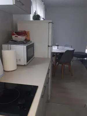 a small kitchen with a microwave and a table at Apartman KIWI in a quite central area in Banja Luka