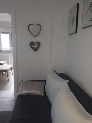 a room with a couch and a heart clock on the wall at Apartman KIWI in a quite central area in Banja Luka