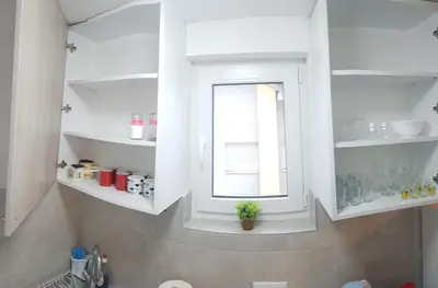 a bathroom with white shelves and a window at Apartman KIWI in a quite central area in Banja Luka