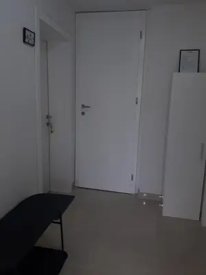 a white room with two white doors and a chair at Apartman KIWI in a quite central area in Banja Luka