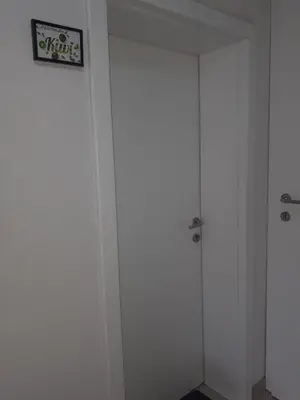 a white closet with a door with a sign on it at Apartman KIWI in a quite central area in Banja Luka